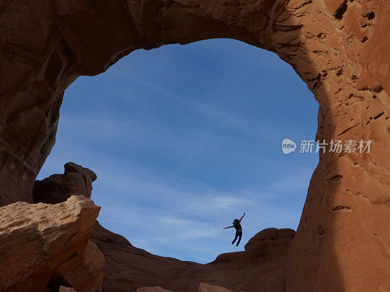 Jumping Mid-air Person Silhouette Inside Broken Arch Round Rock Formation